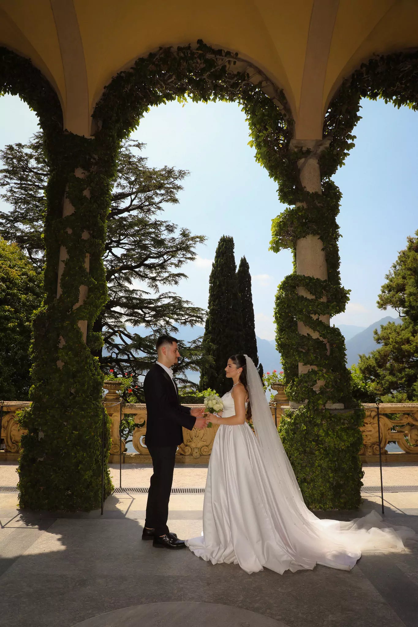 Luxury wedding ceremony beneath the arches at Villa del Balbianello, photographed by Nadia Fraqair